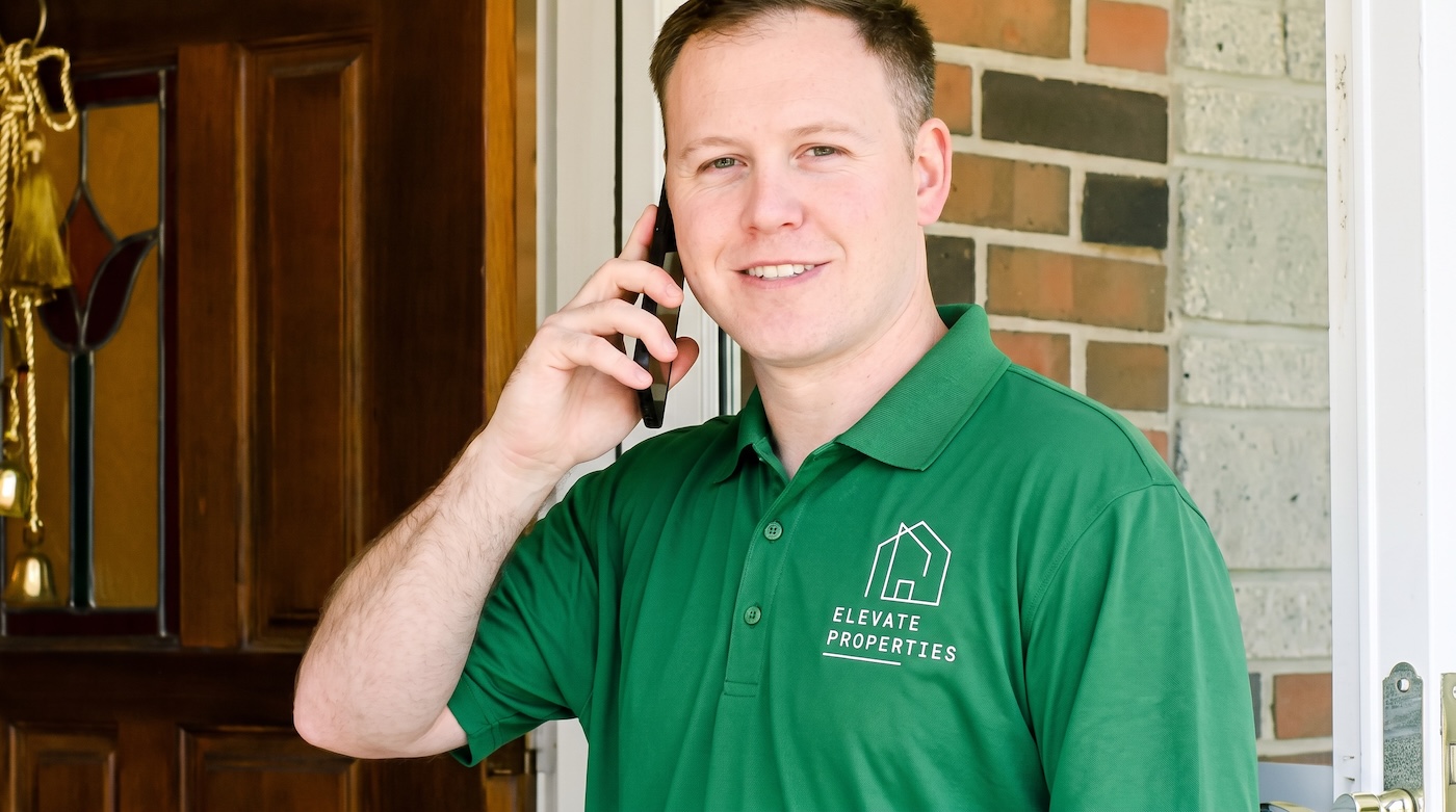 Elevate Properties team member on the phone at a homeowner's front door